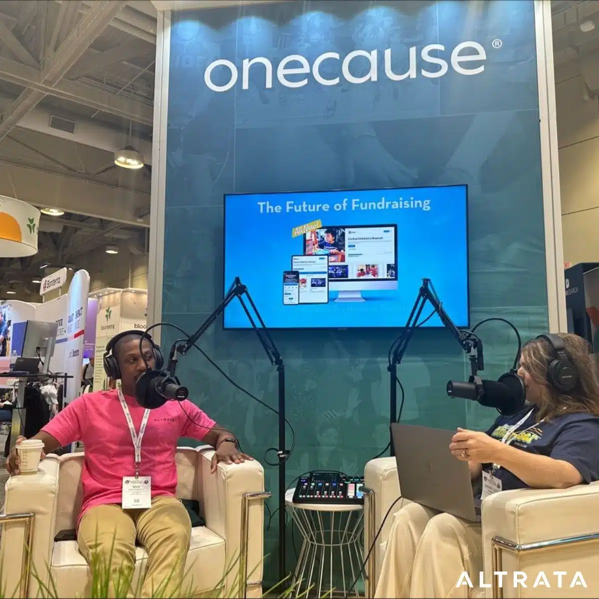 Two people sitting down interviewing for a podcast during a tradeshow