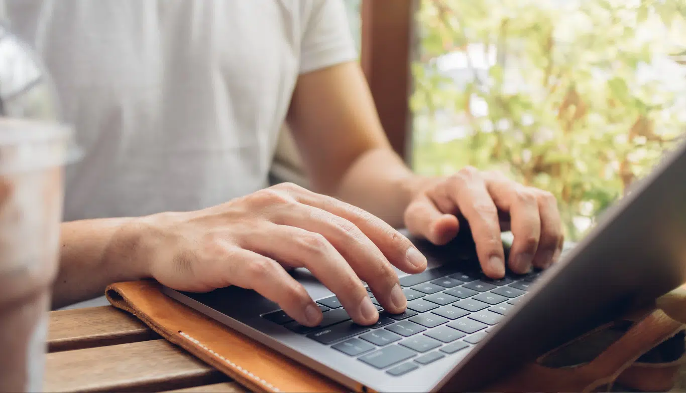 Person typing on a laptop with a bright background