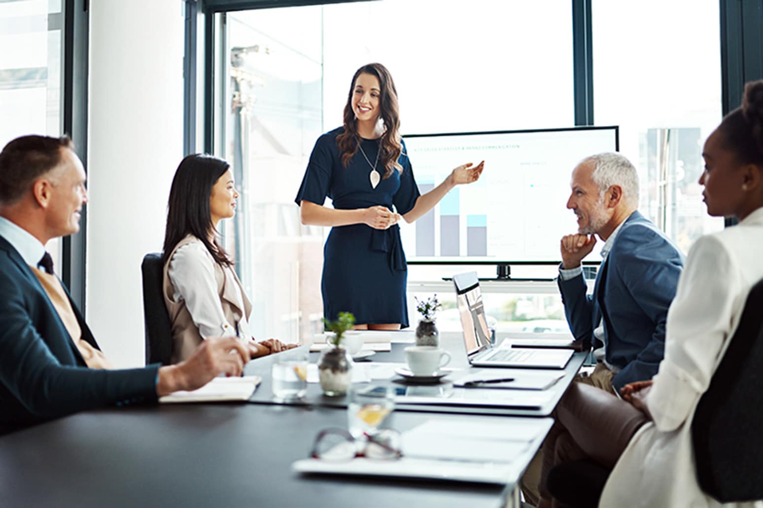 People stand around a boardroom table