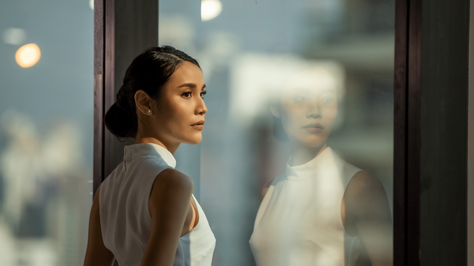 Side profile of a woman looking out of a window, representing UHNW women and their growing influence in global philanthropy.