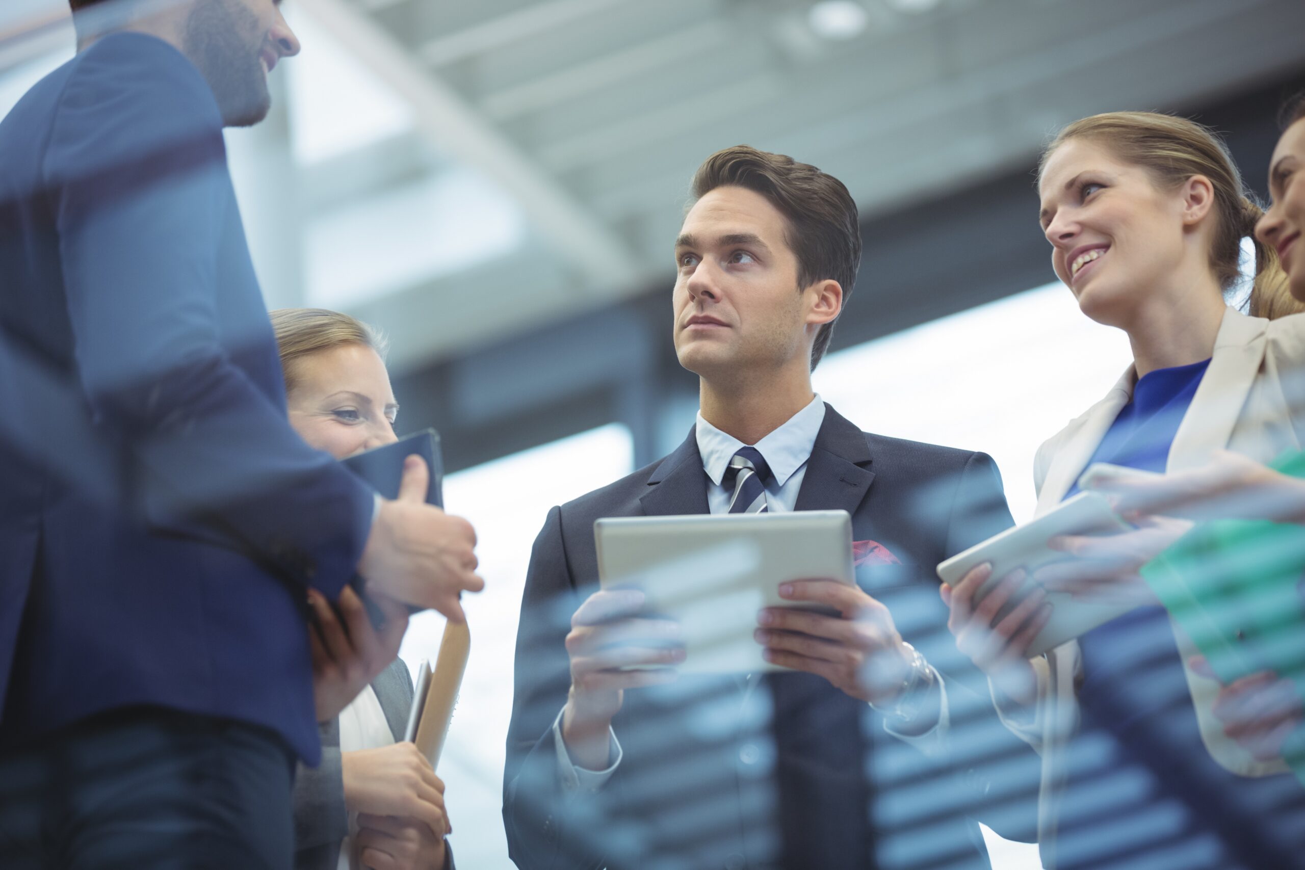 Group of professionals standing together in an office, representing collaboration and relationship-building among centers of influence.