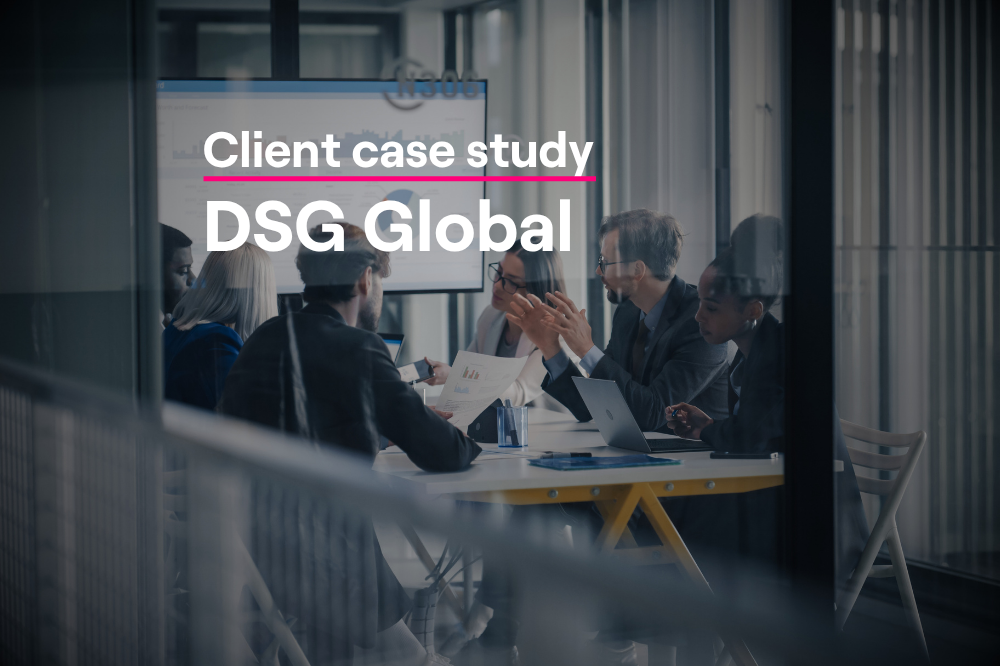 Business team meeting in a glass conference room reviewing data on a screen, illustrating DSG Global's board research process using Altrata's BoardEx